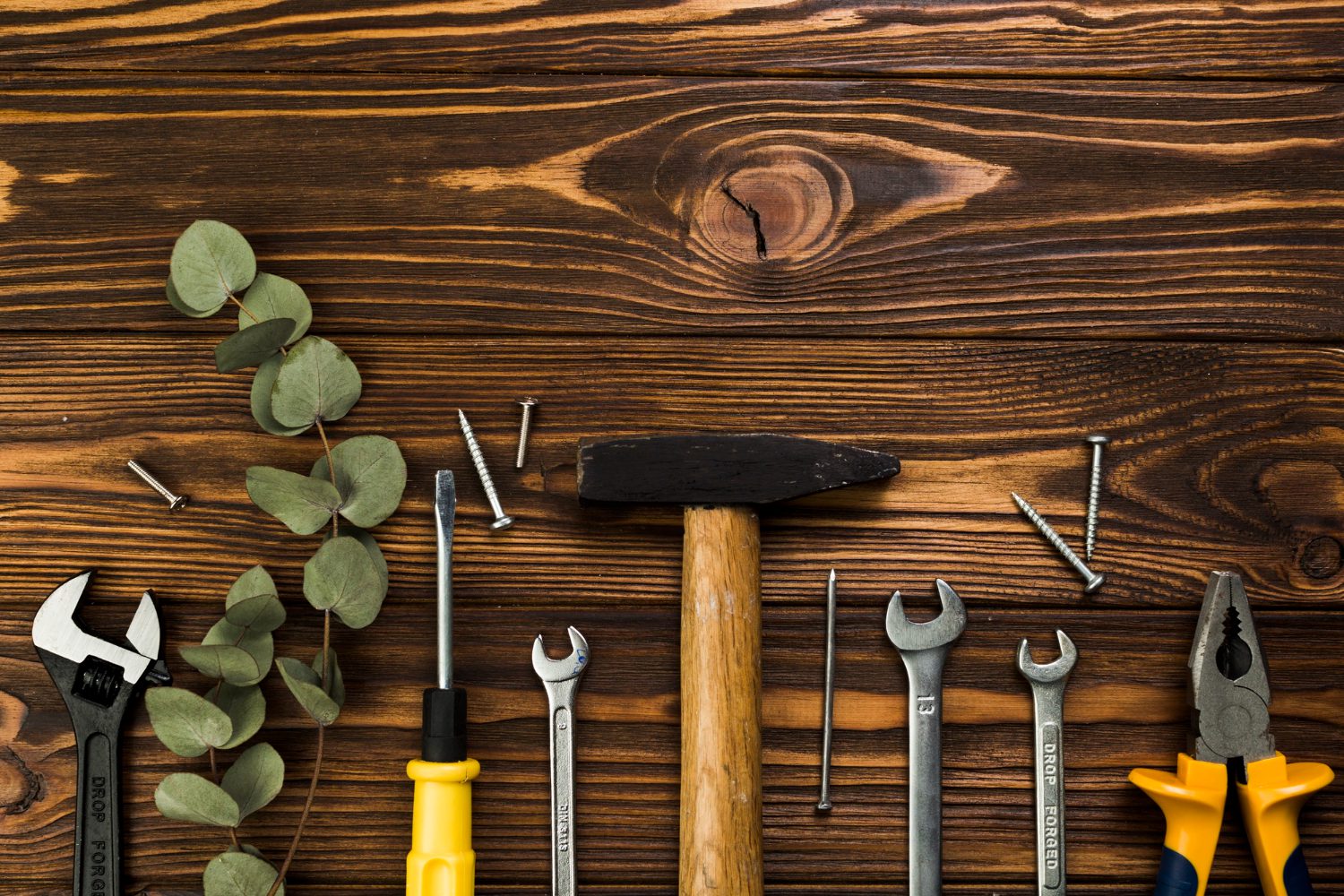 Meistras taiso sugedusį elektrinį įrankį dirbtuvėse.